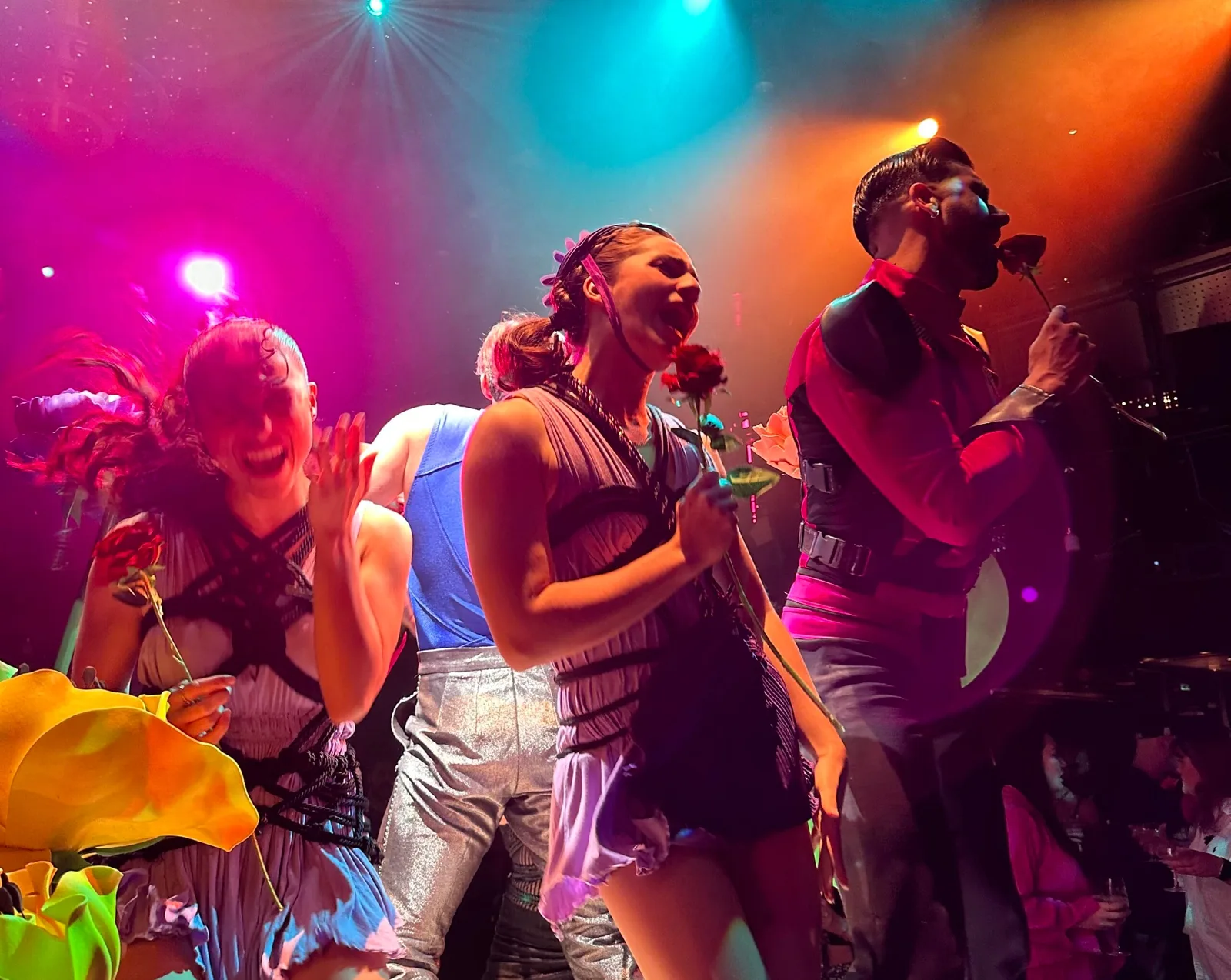 A group of people in colorful costumes and stage lighting appear to be performing or celebrating onboard.