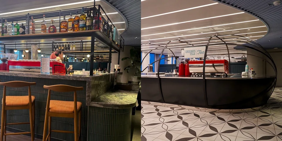 Interior view of an onboard café with a curved coffee bar, red espresso machine, and a sign reading "Grounds Too" under white ceiling lights.